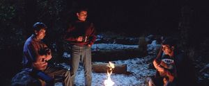 Three weird and grumpy old men, McCoy, Kirk and Spock are in a forest at night, sitting around a campfire, with Spock playing a Vulcan harp while Kirk stands holding a mug and McCoy watches.