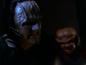 We're on DS9's sister station, Empok Nor. It's dark, but looming out of the darkness is the sweaty, clammy face of a very angry Garak: behind him, out of focus, is a distressed-looking Nog.