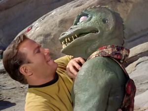 A medium closeup of Kirk and a terrifying rubber lizard man — a Gorn, locked face to face in deadly combat.