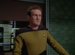 Colm Meany as Transporter Chief O'Brien stands at his console, looking off camera with horror and contempt at the appalling Irish stereotypes that have just appeared on the transporter pad.