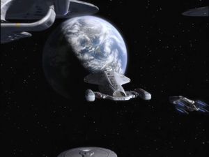 Flanked by a few less interesting Starfleet ships, Voyager finally approaches the planet Earth.
