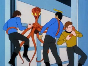 In a corridor on board the Enterprise, McCoy, Spock and Kirk are all being attached by a giant spindly orange cartoon octopus with a row of glowing yellow eyes.