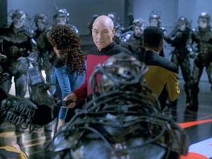 Picard is facing us, flanked by Deanna and Geordi: they are surrounded by Borg