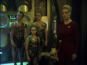 Seven is standing in the corridor of a Borg cube. She looks angry. Behind her, Harry is slumped unconscious. And next to her are three preteen Borg children: two twin boys and a little girl with long hair.