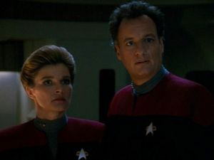 It's Janeway and Q, standing on the bridge of the USS Voyager,  looking at something offscreen with some incredulity.