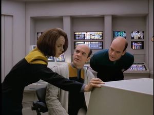 B’Elanna, Dr Zimmerman and the Doctor lean over a console.