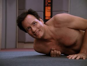 It's Q, lying on the carpet on the floor of the Enterprise bridge. He's naked, with a wicked grin on his face.