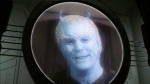 The blue Andorian face of Shran (Jeffrey Coombs) grins from a circular monitor screen.